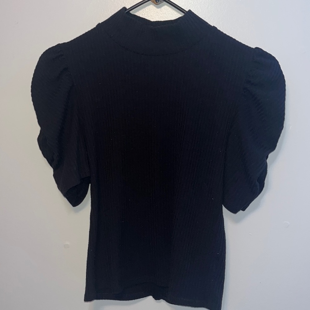 Black fitted top with puffy short sleeves and a turtleneck.